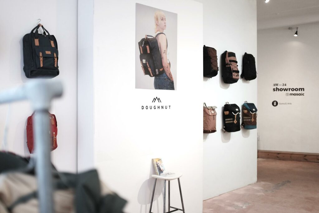 Doughnut brand corner at this year's Mosaic AW—24 Showroom in Berlin with various backpacks being attached to a white wall