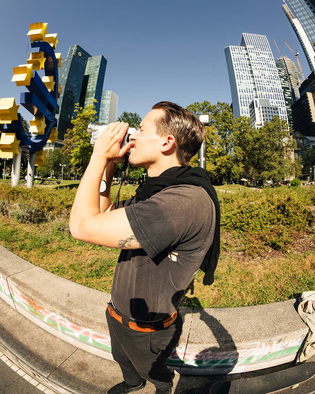 Portrait of skateboarder and Mosaic marketing director Philipp Schäfer looking through the viewfinder of an old VHS camera at Willy-Brandt-Platz in Frankfurt, Germany.
