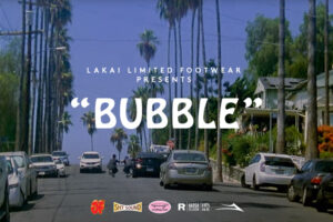 Movie poster for Lakai's latest "Bubble" video that shows a Los Angeles road with palms and skaters pushing up the hill. The center says "Bubble" in bubbly white letters and the bottom shows some additional logos.