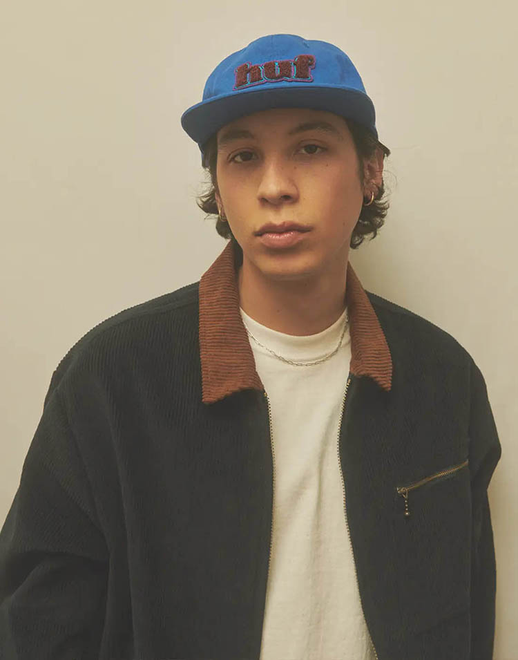 Portrait of a young men facing the camera and wearing a blue HUF cap