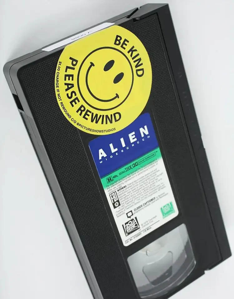 Old Alien VHS tape from a movie rental with a yellow sticker that shows a smiley and the words be kind, please rewind