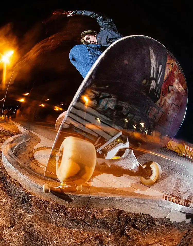 Action photo of German skateboarder André Gerlich performing a Slappy Overcrooks on a curb