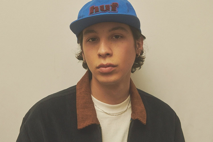 HUF Spring 2023 collection teaser showing a portrait of a young man with a blue cap that says HUF